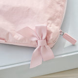 Pink pouch with a bow and a visible brand tag on a light gray background
#color_ballet pink bow
