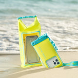 Two yellow phone cases with blue straps on a sandy beach with water in the background.
#color_citrus splash