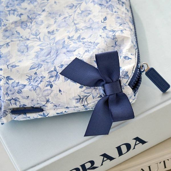 Floral pouch with a navy ribbon
on a Prada box
#color_something navy bow