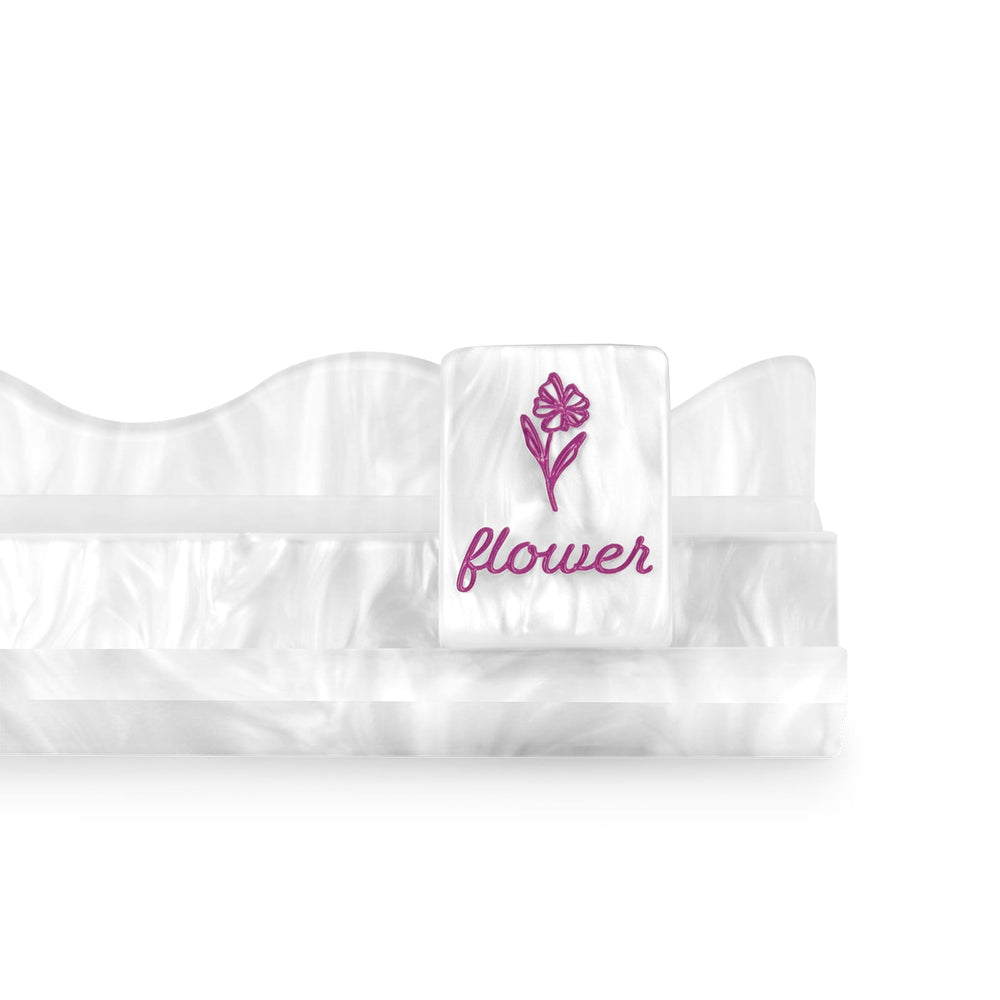 A white ruffled baby garter belt with a central strap featuring an embroidered pink flower and the word 'flower' in pink 
#color_ivory pearl