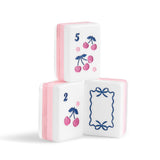 Three white decorative mahjong-style tiles stacked in a pyramid on a white background. The top tile shows pink cherries with a blue number 5, the bottom left tile shows pink cherries with a blue number 2, and the bottom right tile has a blue bow frame design.
#color_ballet pink pearl edition