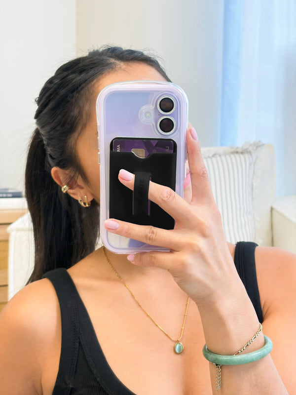 Person holding a phone with a purple case in front of their face, wearing a black top and gold jewelry.
#color_midnight black