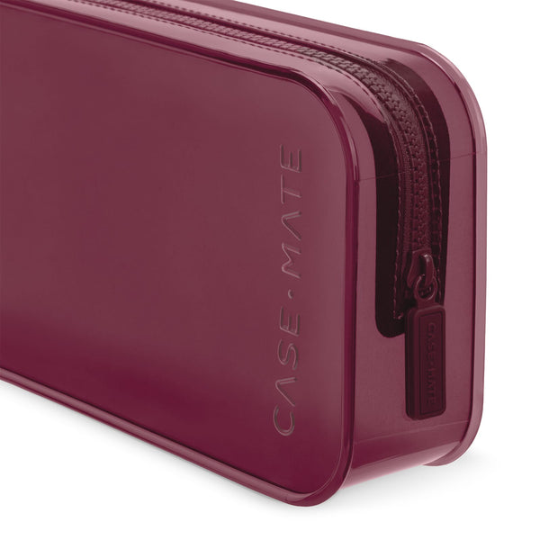A close-up of a translucent burgundy zippered case with the brand name 'CASE-MATE' debossed vertically on the side and a matching zipper pull tab.

#color_mulberry
