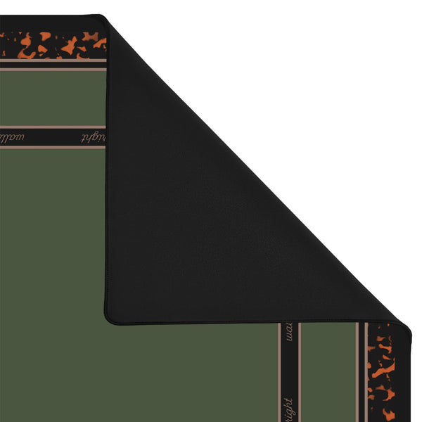 A folded black mat or rug shown on a white background, with part of the patterned reverse side visible. The visible pattern includes dark brown bands with small orange motifs and some light text.
#color_classic tortoiseshell