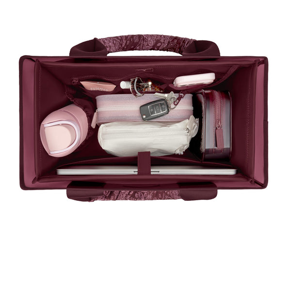 An open burgundy bag with a patterned handle and interior organizer pockets, shown from a top-down view with various travel accessories and a laptop packed inside on a white background.
#color_mulberry