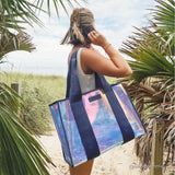 Woman facing towards the beach standing on the boardwalk with plants around her #color_oxford navy iridescent