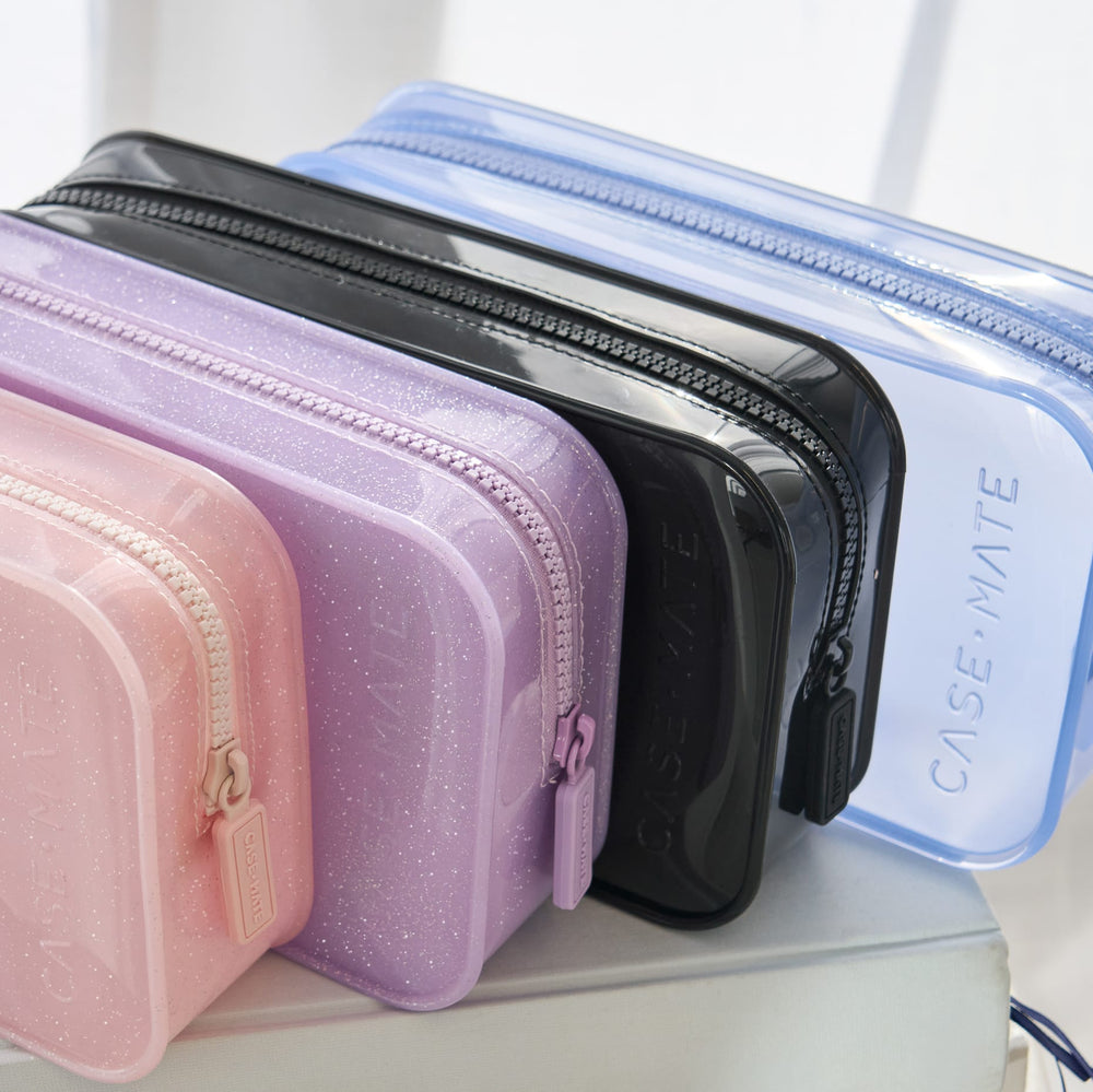 Set of clear plastic zippered pouches in various colors on a white surface.