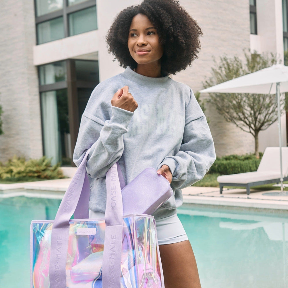 Woman holding a colorful tote bag by a poolside