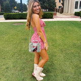 Woman in a red and white checkered dress with white boots standing on grass.

#color_silver chrome