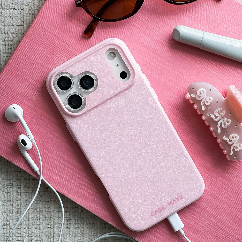 Pink phone case with 'Case-Mate' branding on a pink surface with earphones and sunglasses.