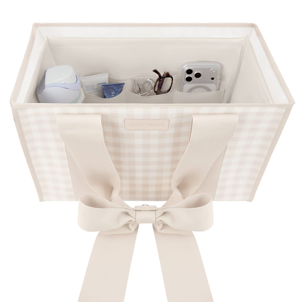 A cream-colored fabric organizer box with a gingham pattern and a large ribbon bow on the front, shown open with various small accessories stored inside against a white background.
#color_french vanilla 