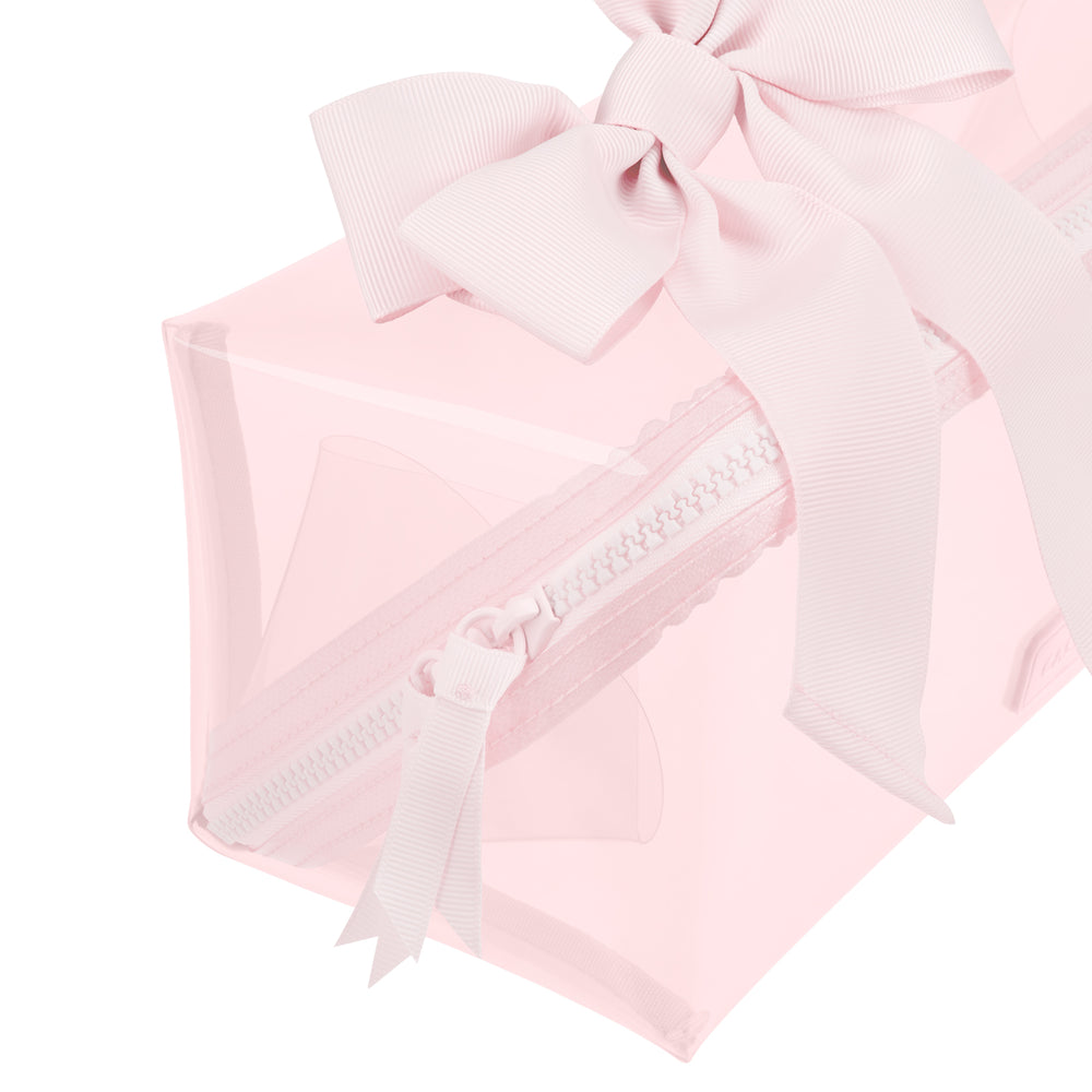 A light pink translucent zippered pouch with a matching pink grosgrain ribbon bow on top, shown against a solid white background.
#color_ballet pink bow