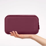 A burgundy zippered travel pouch held by a person's hand against a clean white background. The brand name 'CASE-MATE' is embossed vertically on the right side of the pouch.
#color_mulberry