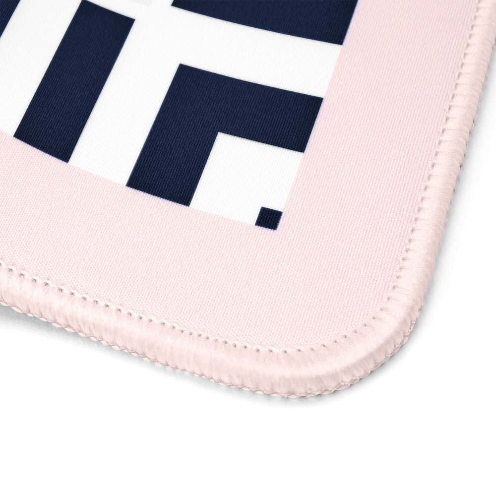 Close-up of a light pink stitched fabric item, likely a mouse pad or mat, showing a white section with bold navy geometric lettering on a white background.
#color_classic cabana stripe