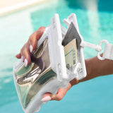 Hand holding a clear plastic wallet with money and a card against a blurred pool background #color_ivory twinkle