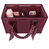 A burgundy tote organizer bag shown from above, filled with travel accessories including a pink tumbler, a phone case, a small box, and a scarf tied to the handles. 
#color_mulberry