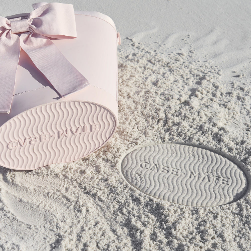 bottom of cooler with "case-mate" branding imprinted into the sand from the base of the cooler bag leaving a mark #color_ballet pink bow