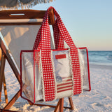 Clear beach bag with red checkered cover on a wooden chair at the beach  
#color_Cherry Gingham