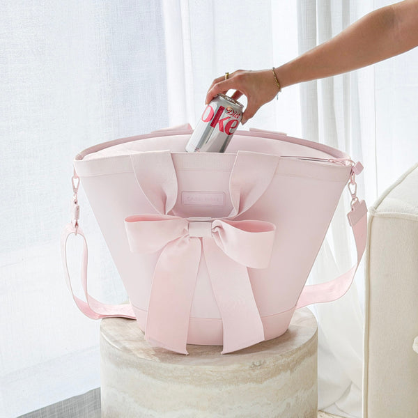 Pink tote bag with a bow being held by a hand against a light background
#color_ballet pink bow