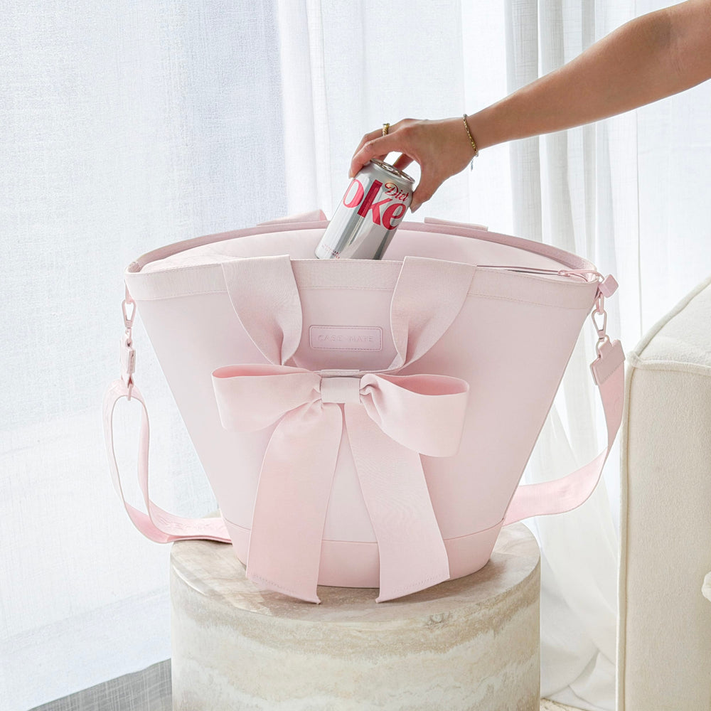 Pink tote bag with a bow being held by a hand against a light background
#color_ballet pink bow