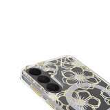 A close-up of a clear phone case with a metallic gold and silver glitter floral pattern, fitted on a smartphone with a dual-camera system, shown against a plain white background.
#color_floral gems