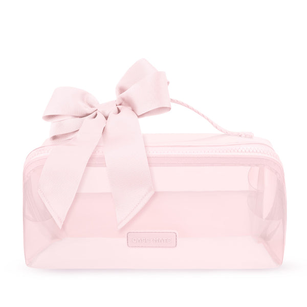 A light pink transparent zippered cosmetic bag with a large matching pink satin bow on top and a small rectangular brand plaque on the front.
#color_ballet pink bow