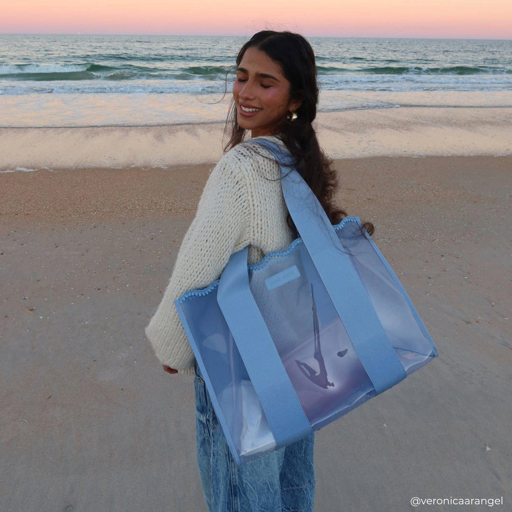 Woman holding a blue tote bag on a beach at sunset
#color_carolina blue crochet wave