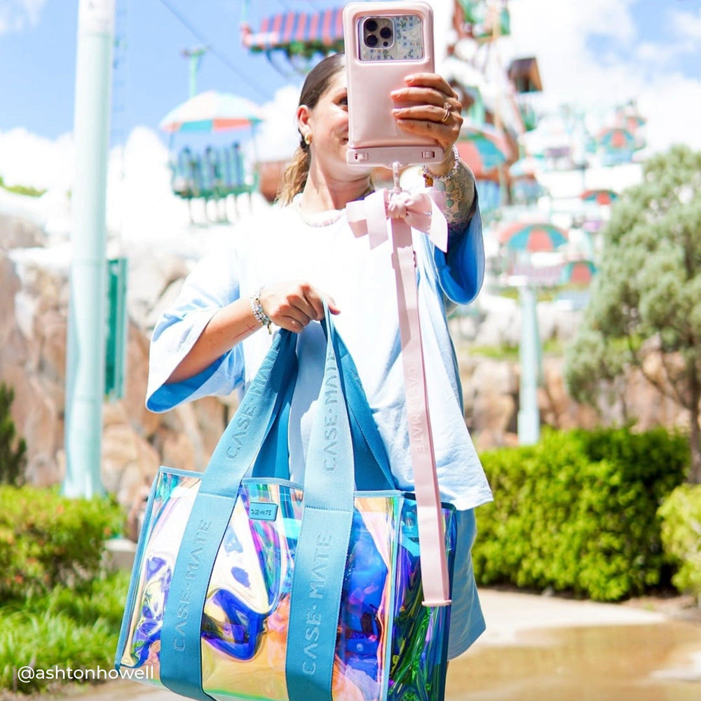 Person taking a selfie with a colorful bag and phone case at Disney Parks 
#color_emerald blue soap bubble®