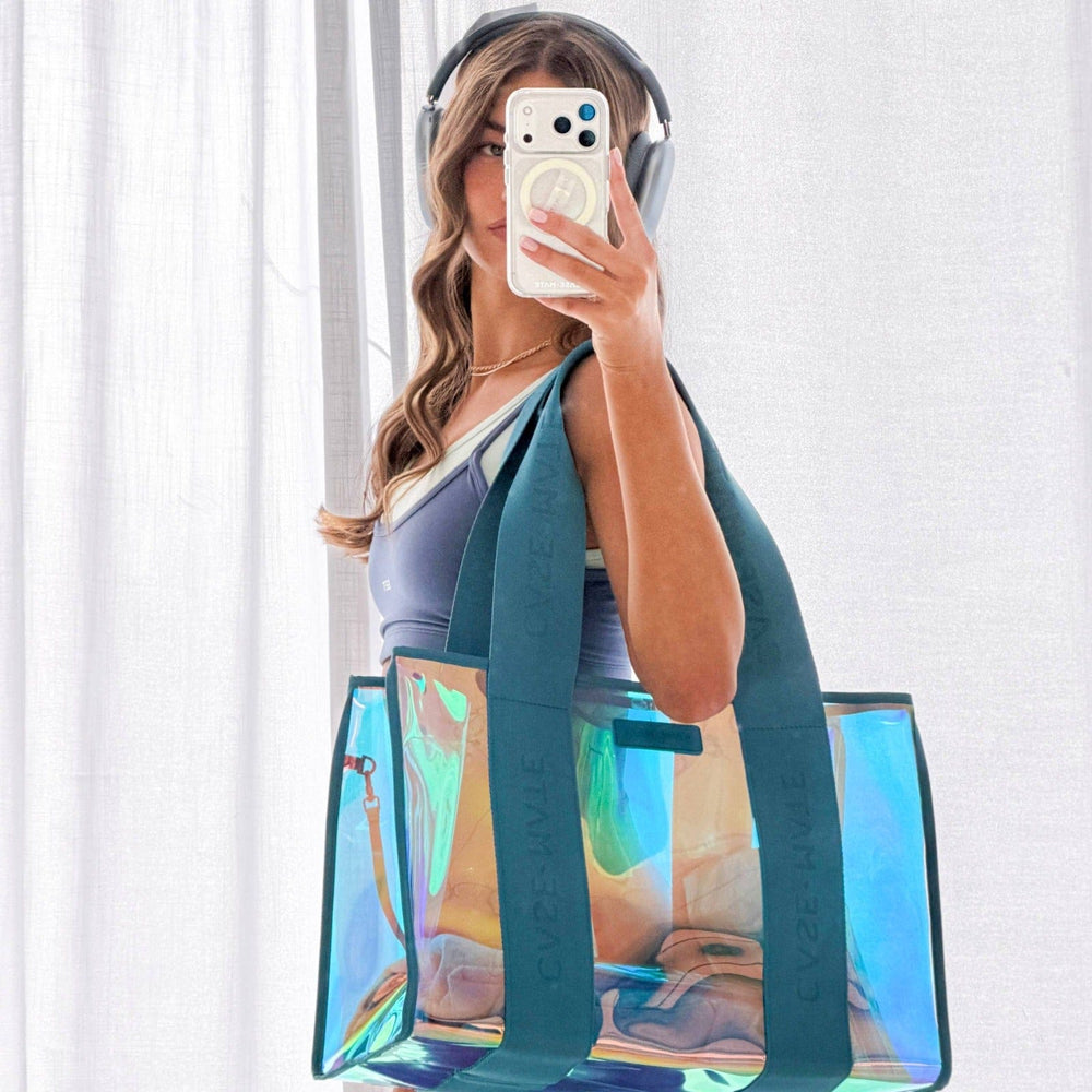 Person holding a transparent tote bag with colorful design, wearing headphones and taking a mirror selfie.
#color_emerald blue iridescent