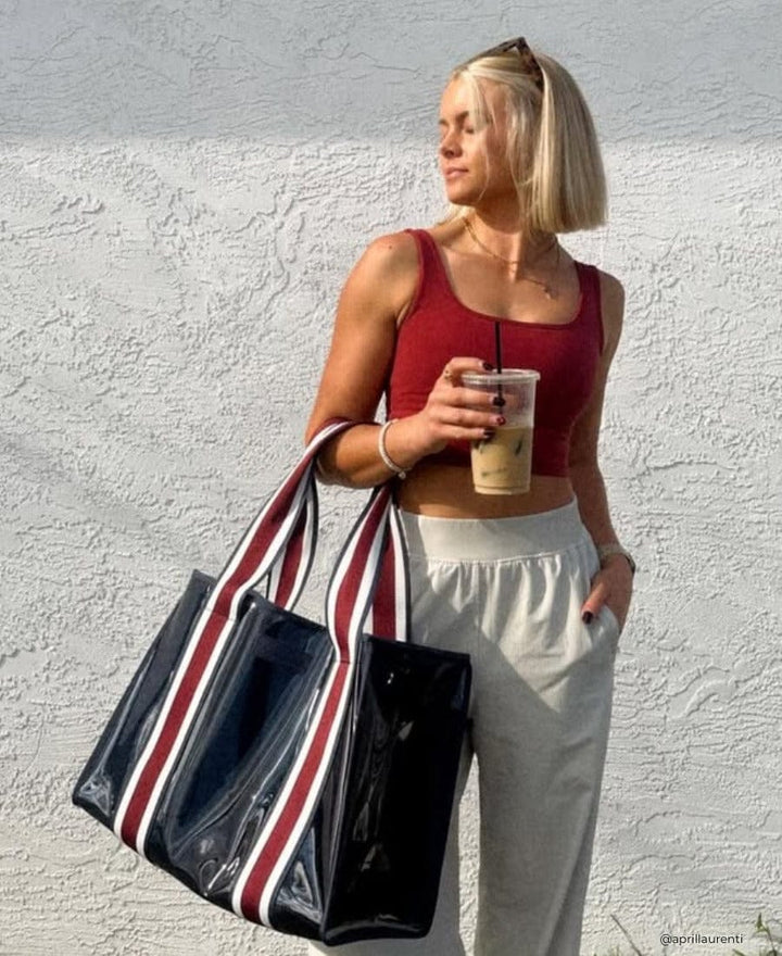 Girl standing in the sun with an iced coffee and Navy Rugby Stripe Jelly Tote