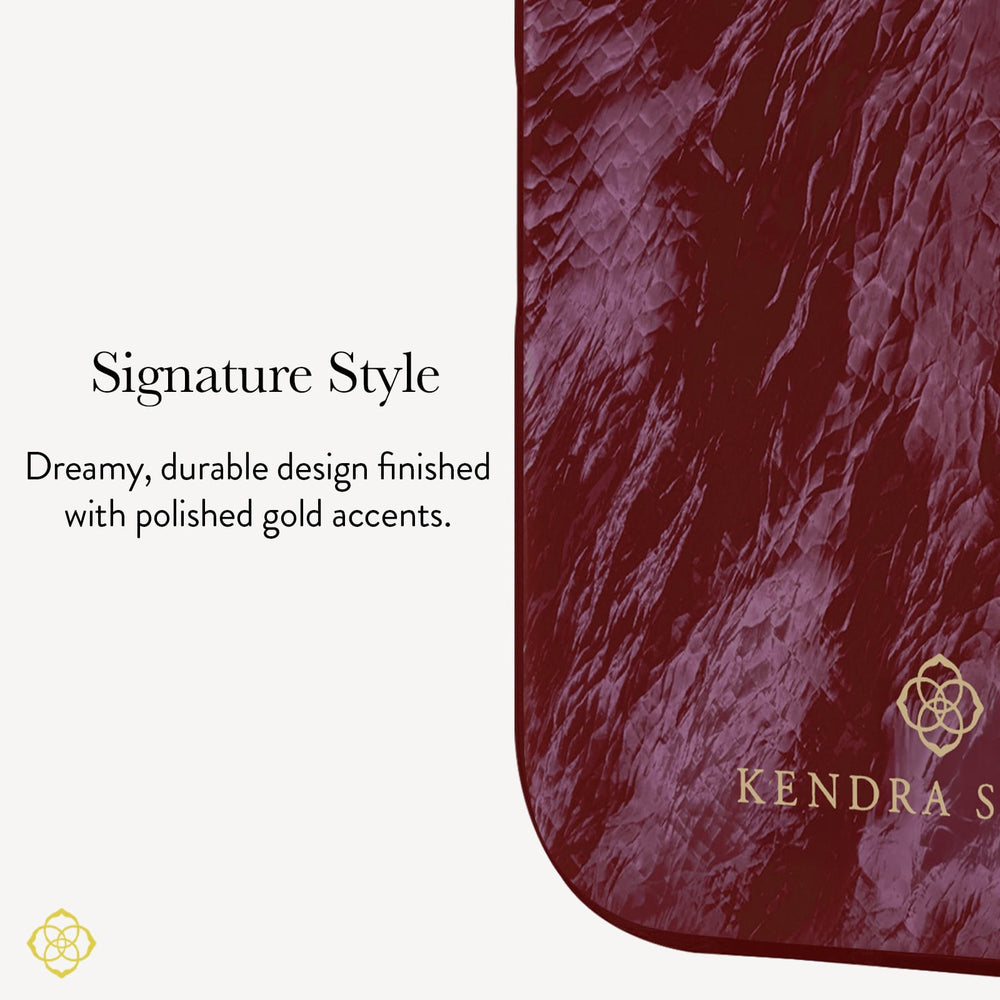 A close-up of a textured burgundy pouch or case with rounded corners, featuring a gold KENDRA SCOTT logo and text that reads 'Signature Style' and ' Dreamy, durable design finished with polished gold accents.'
#color_cherry lacquer pearl