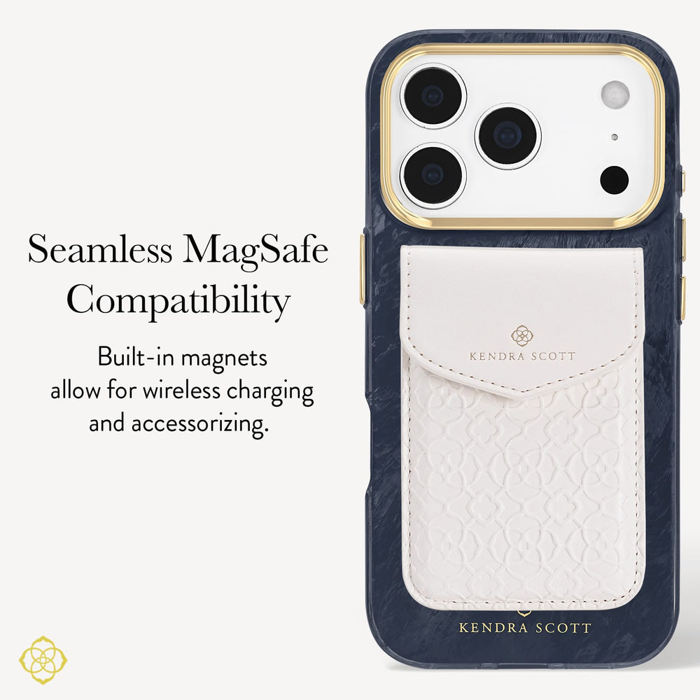 A Kendra Scott phone case shown on a light gray background with promotional text. The case is dark navy blue with a textured leather card pocket in off-white/cream and gold trim around the camera cutout and branding. Highlighting seamless MagSafe compatibility

#color_navy pearl