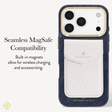 A Kendra Scott phone case shown on a light gray background with promotional text. The case is dark navy blue with a textured leather card pocket in off-white/cream and gold trim around the camera cutout and branding. Highlighting seamless MagSafe compatibility

#color_navy pearl
