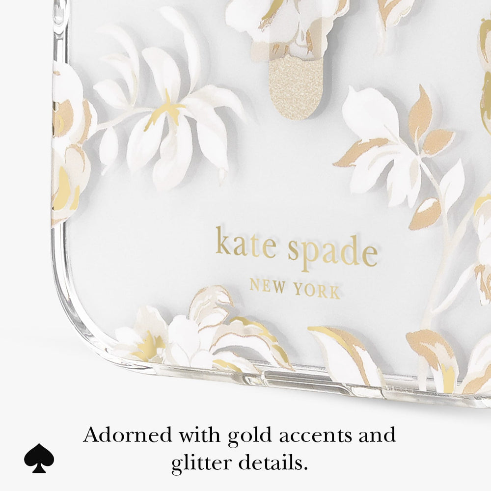 A close-up of a clear phone case with white and gold floral artwork and gold 'kate spade NEW YORK' lettering, shown on a white background with text below reading 'Adorned with gold accents and glitter details.'.
#color_autumn toile
