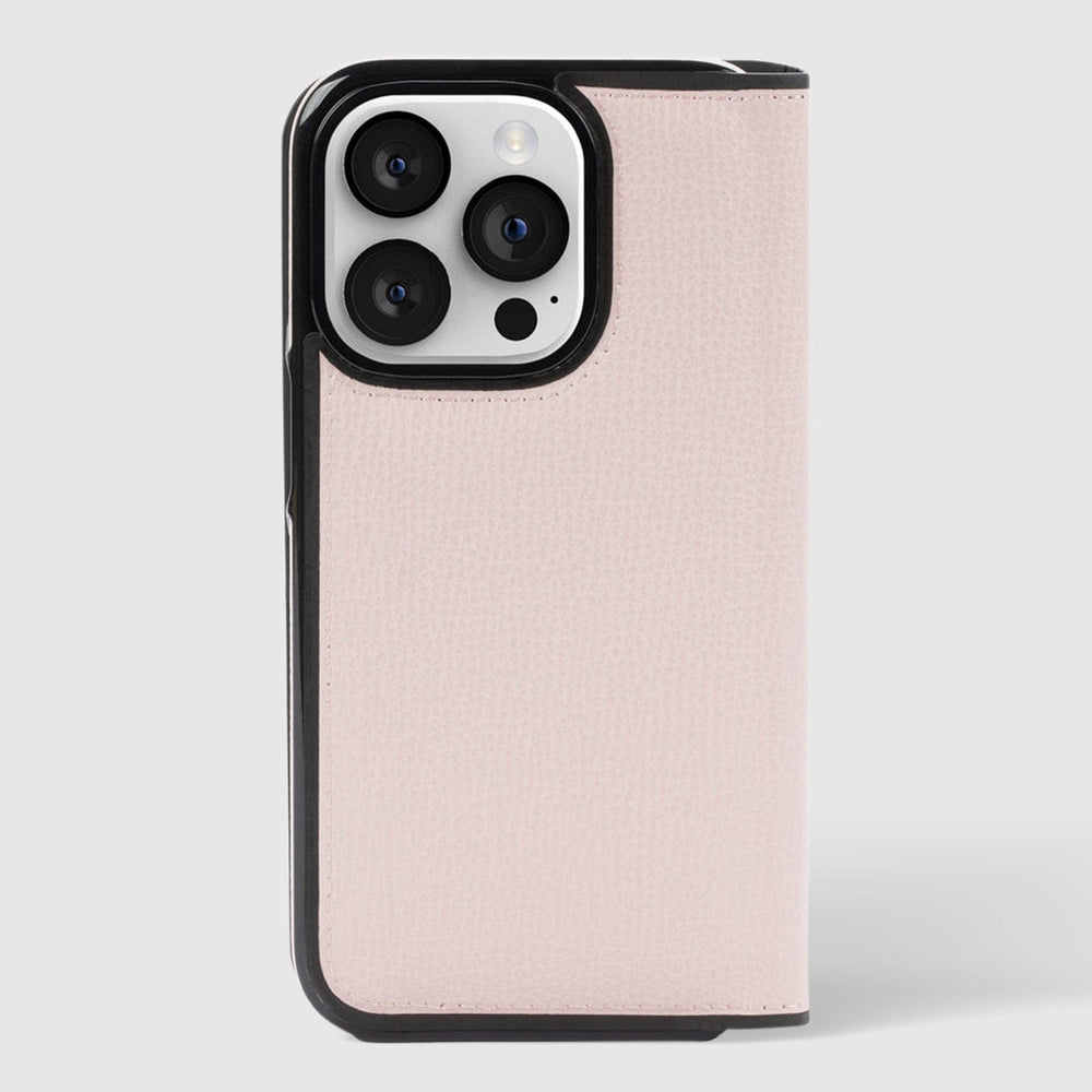 Pale vellum wrap folio case for iPhone 15 Pro Max with black trim and card slots, shown open to display triple camera cutout.