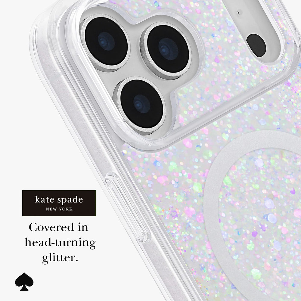 A close-up of a Kate Spade New York phone case with a clear bumper and a back covered in iridescent holographic glitter. The case is shown fitted on a phone, with the brand name and text 'Covered in head-turning glitter.
#color_chunky glitter