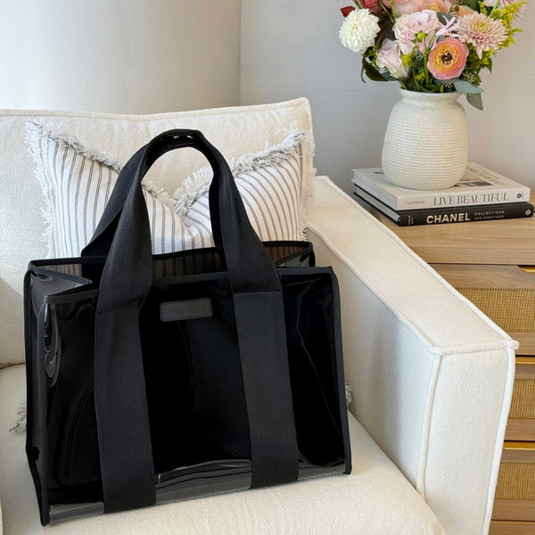 Black bag on a white couch with a vase of flowers and books in the background
#color_midnight black