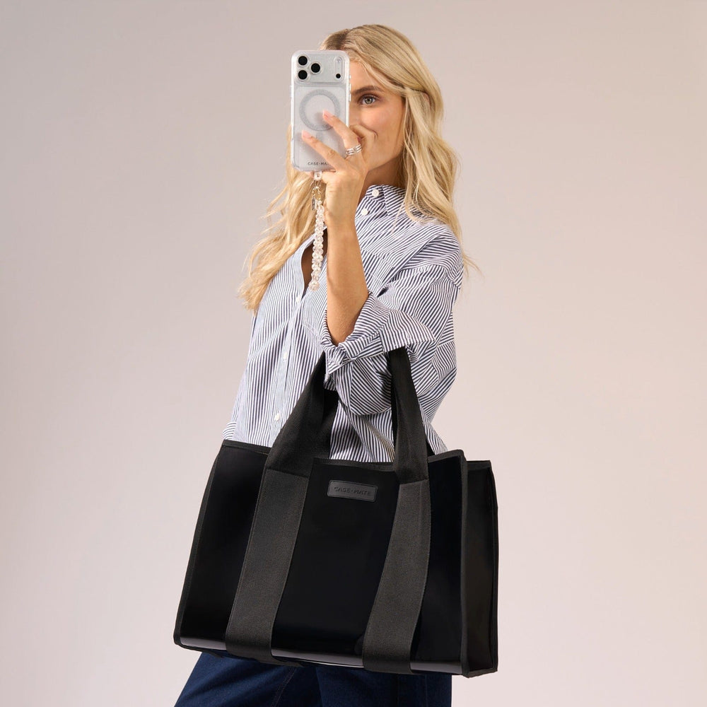 Woman holding a black tote bag with a neutral background
#color_midnight black