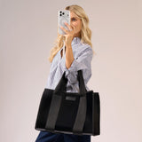 Woman holding a black tote bag with a neutral background
#color_midnight black