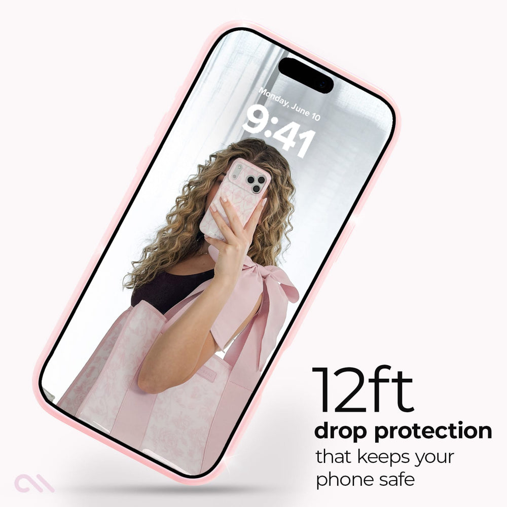 A smartphone shown at an angle with a pale pink protective bumper around the edges. The screen displays a mirror selfie wallpaper with the text '12ft drop protection that keeps your phone safe' on a clean white background.
#color_ballet pink twinkle
