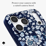 A close-up of a phone case with a navy blue background and a white and light blue floral pattern, featuring a raised bezel around the camera cutout. Text at the top reads 'Protect your camera with a raised bezel.
#color_flowerbed navy