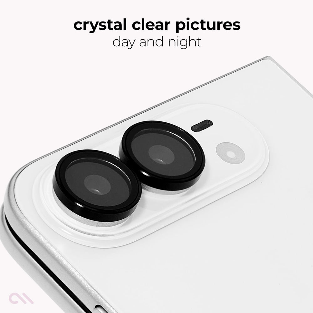 A close-up of a white smartphone showing two black circular lens protectors installed over the rear camera lenses. Text at the top reads 'crystal clear pictures day and night' on a clean white background.