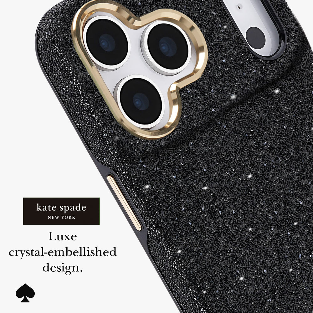 Kate Spade New York Luxe crystal-embellished black phone case with a gold heart-shaped camera bezel, shown on a white background with product text and logo.
#color_crystal pavé