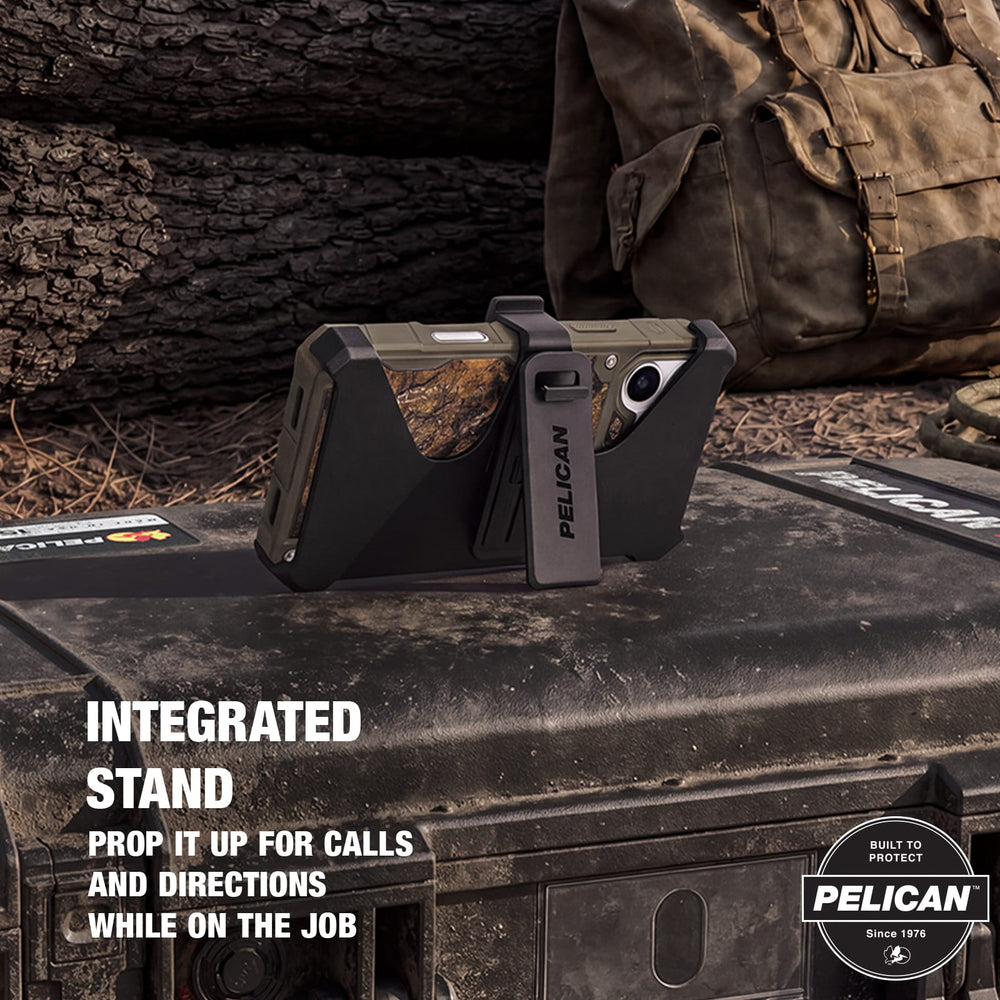 Pelican rugged phone case with integrated black stand, shown holding a smartphone upright on a dark outdoor surface with camouflage-patterned inner panel. Text on image reads 'INTEGRATED STAND PROP IT UP FOR CALLS AND DIRECTIONS WHILE ON THE JOB' and includes Pelican badge.
#color_shield elements hunter camo
