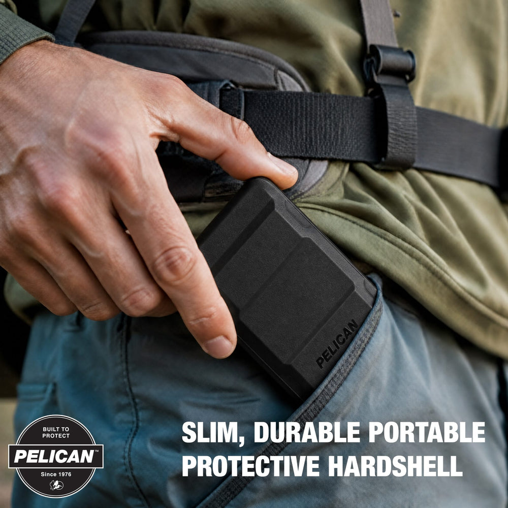 A close-up of a person wearing a black Pelican slim, durable portable protective hardshell battery pack in a utility pocket, with text overlay and a Pelican badge in the corner.