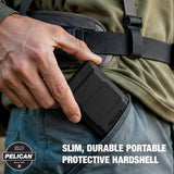 A close-up of a person wearing a black Pelican slim, durable portable protective hardshell battery pack in a utility pocket, with text overlay and a Pelican badge in the corner.