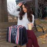 Woman sitting on a bench with a large tote bag and a drink, autumn setting
#color_navy rugby stripe