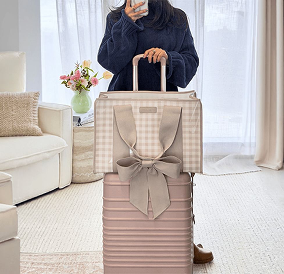 The jelly tote resting on a carry-on suitcase