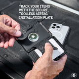 Black MagSafe wallet with circular AirTag holder being held open to display card slot and tracking device compartment.