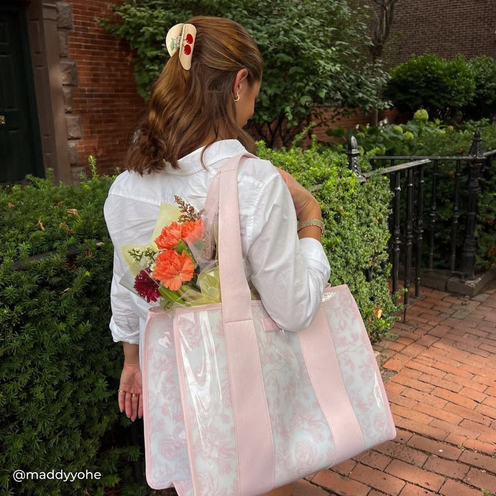 Girl with flowers in tote walking on sidewalk #color_ballet pink afternoon rosé